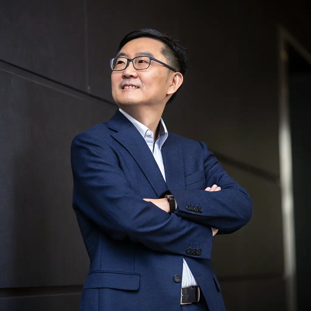 A professional headshot of the Zhengtu International Chief AI Scientist, Dr. Jian Li, smiling confidently. He is wearing a suit and tie, and the background is a blurred office setting.